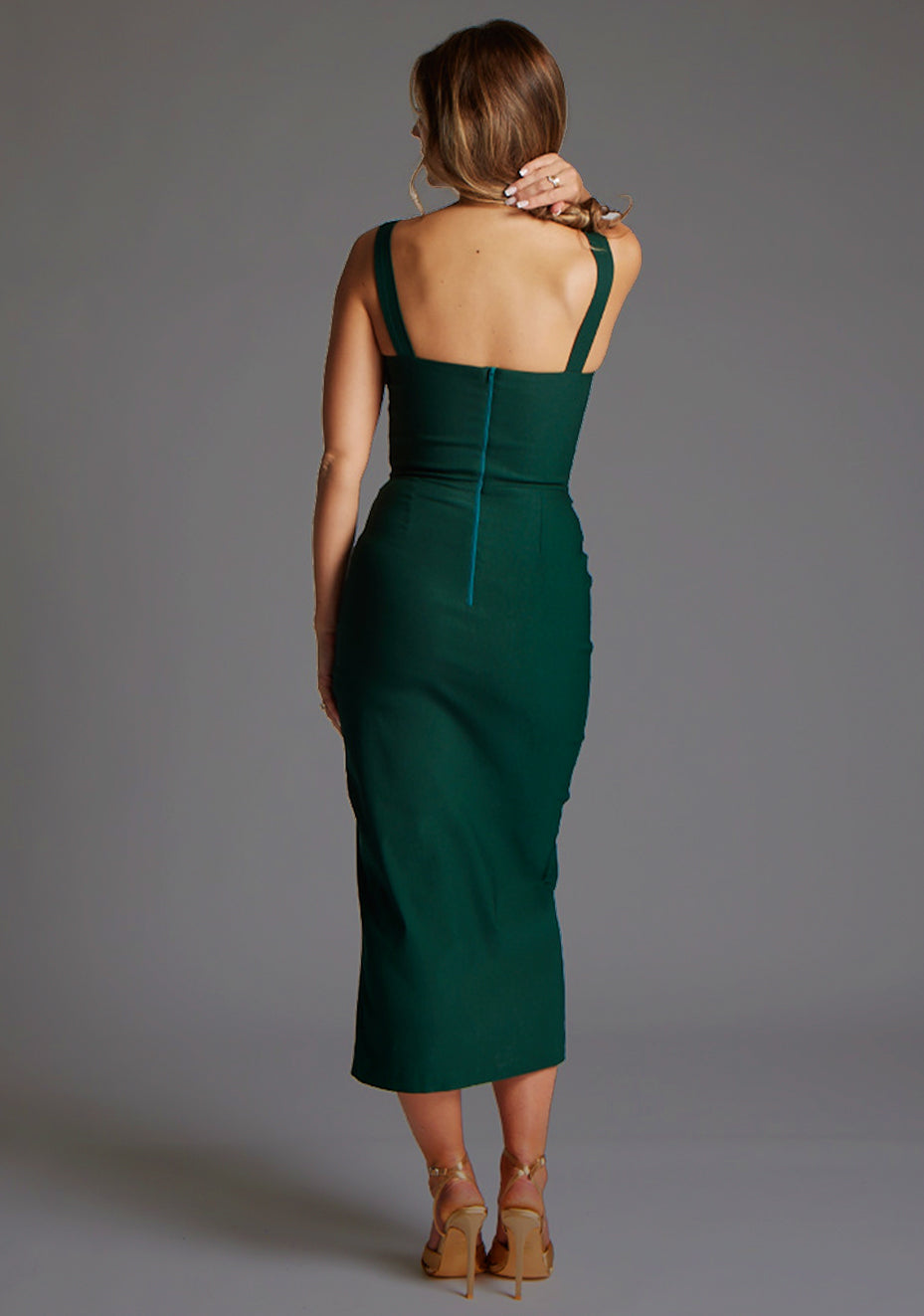 Back image of a model wearing forest midaxi dress with a flattering sweetheart neckline and a faux wrap at the skirt, creating a sophisticated and elegant look. The design featured is the Vesper Farrah Sweetheart Neckline Midaxi Dress in Forest Green.