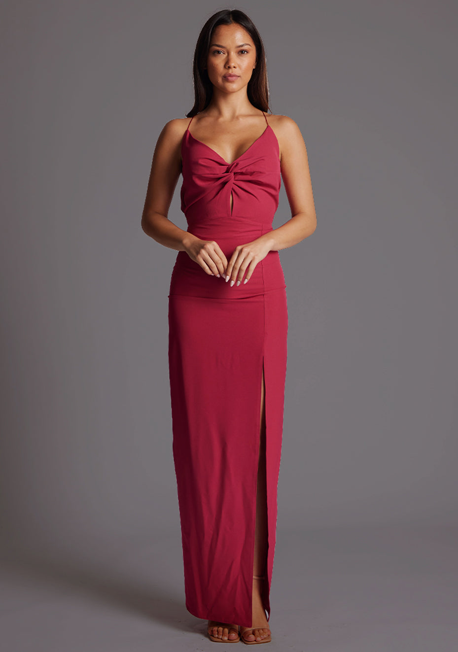 Front image of a model wearing the Vesper Maggie Sweetheart Neckline Maxi Dress in Raspberry, featuring a flattering sweetheart neckline, front skirt split, and flowing maxi silhouette, against a grey studio backdrop.