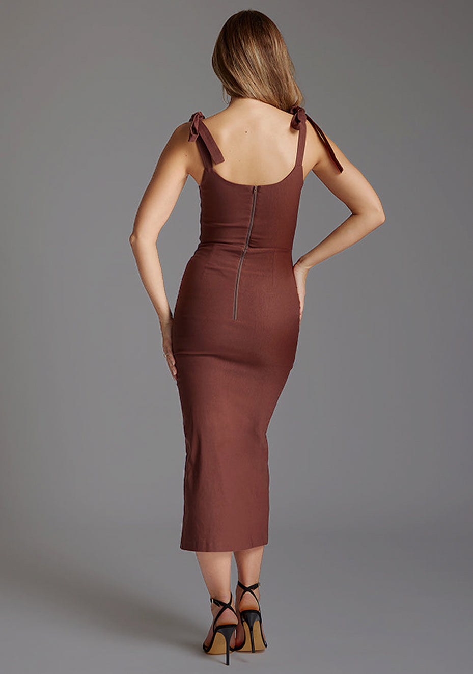 Back image of a model wearing the Vesper Onyx Square Neck Bow Midaxi Dress in Chocolate, showcasing the clean back silhouette, body-hugging fit, and elegant midaxi length.