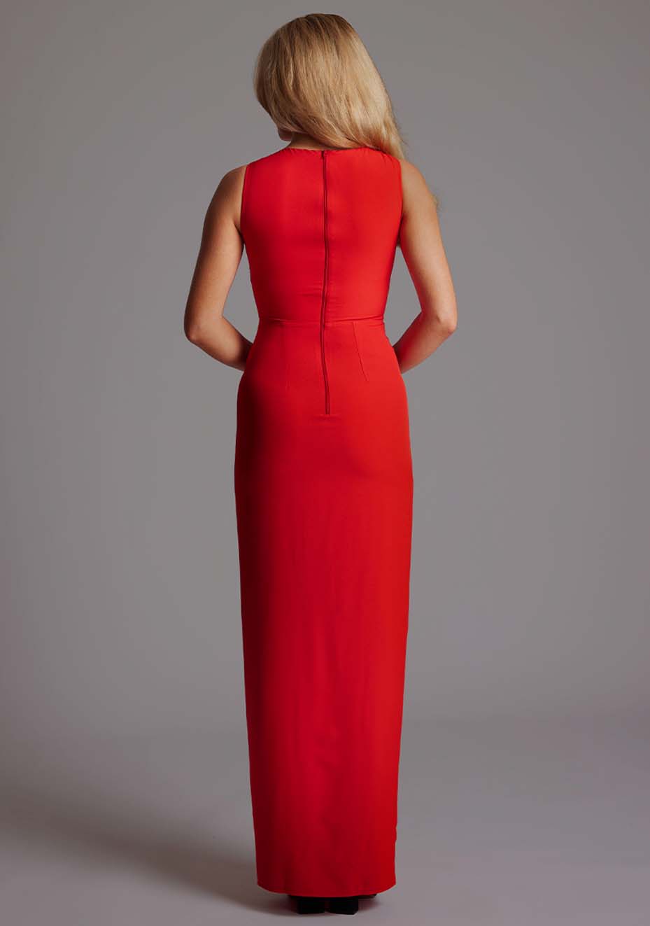 Back image of a model wearing the VSPR Polly Asymmetrical Maxi Dress in Red highlighting the smooth back zip closure and flowing maxi length.