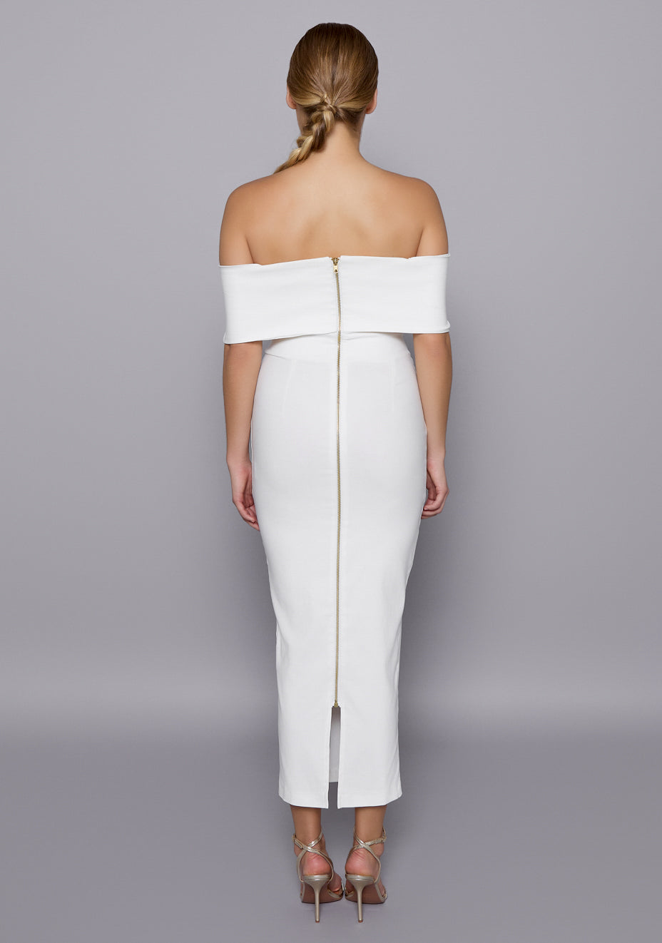 Back view of the VSPR Sarah Ivory Bardot Dress featuring a sleek gold zip closure and fitted silhouette, revealing clean lines and elegant back shaping.