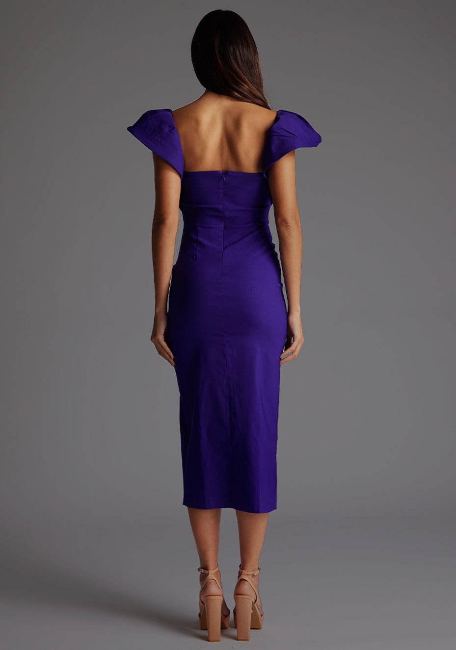 Back image of model wearing a purple frill sleeve midaxi Dress with a sweetheart neckline, short frill hem cap sleeves and a front skirt split. The design featured is the Vesper Sunday Purple Frill Sleeve Midaxi Dress.