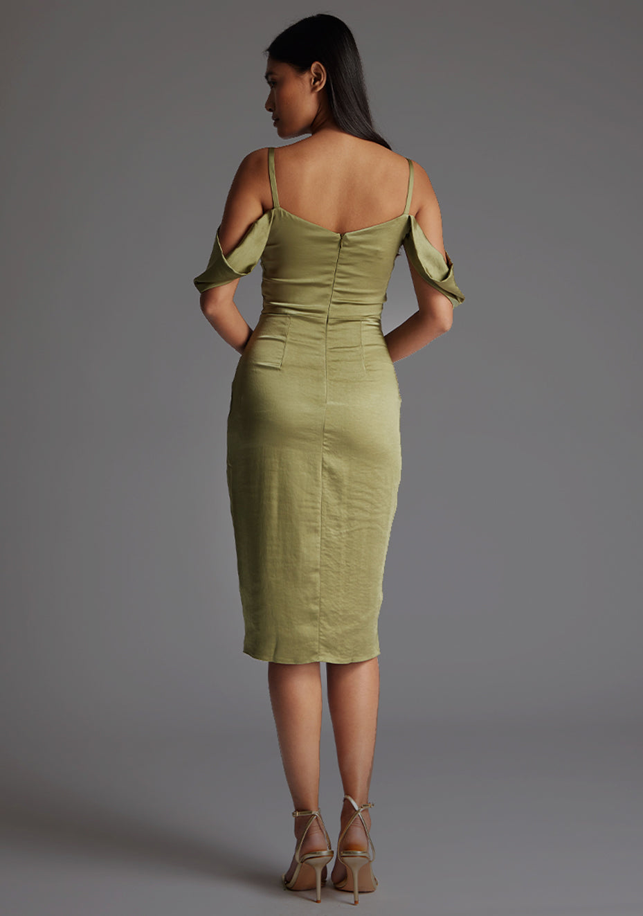 Back image of model wearing a olive satin bardot midi dress with a  delicate allure satin, cowl neckline and invisible back zip with thin straps and draped arm bands.  The design featured is the Vesper Victoria Olive Satin Bardot Midi Dress